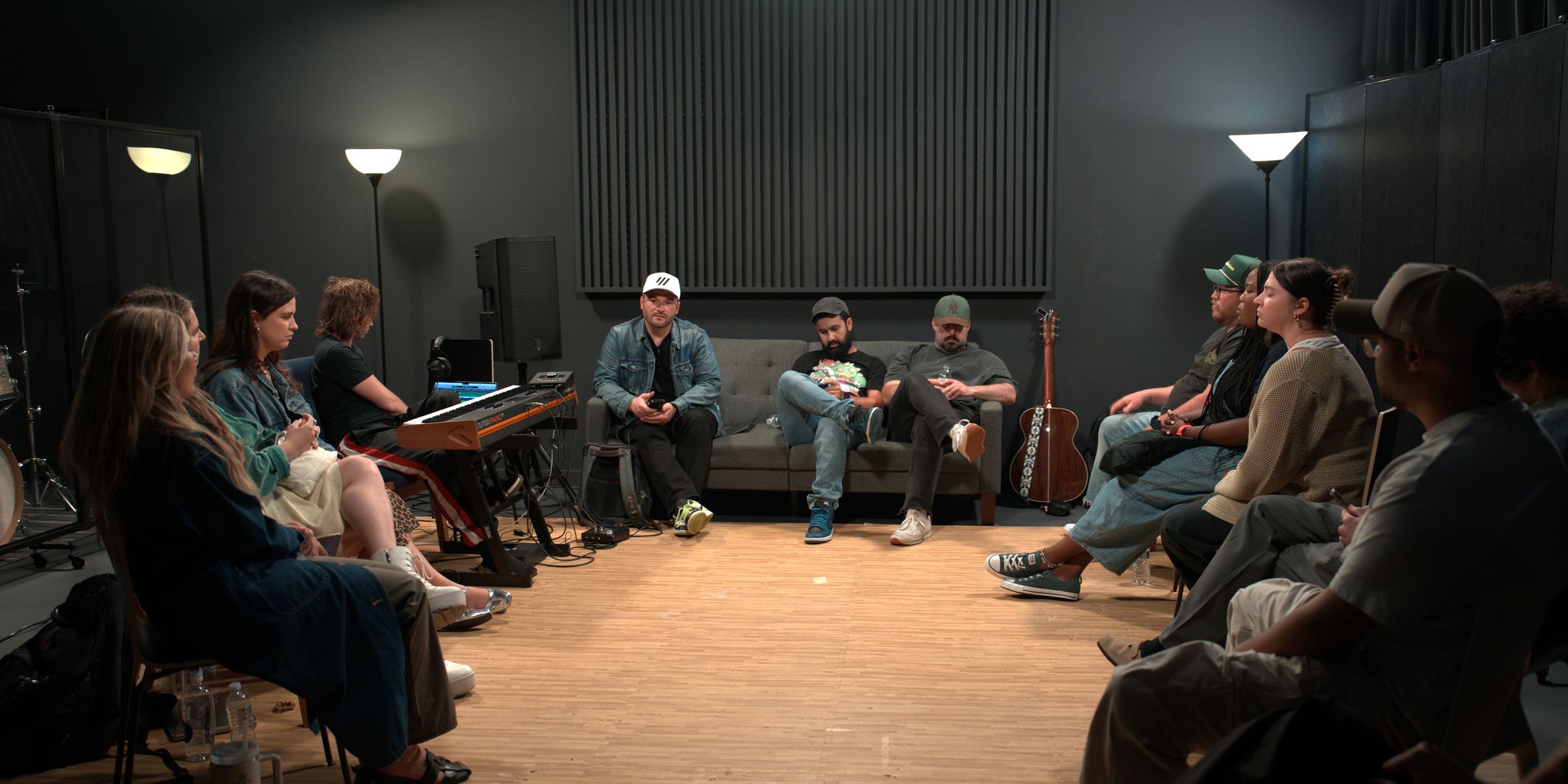 A circle of songwriters in a studio writing room